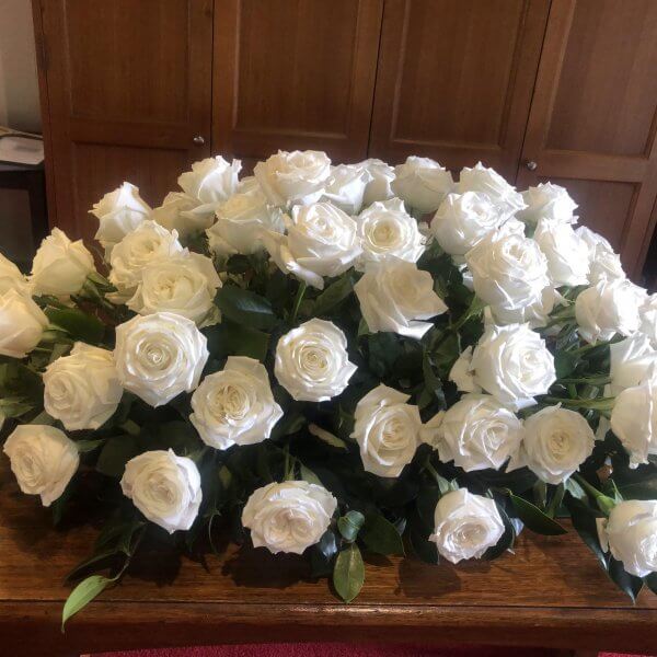 White sympathy roses on casket for Gelong funeral